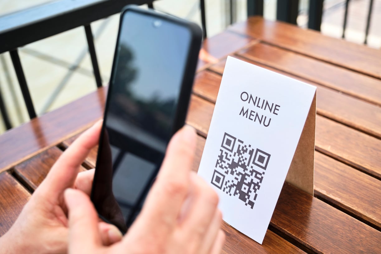 Hands of an Unrecognizable Woman Scanning a QR Code to Access a Restaurant Menu